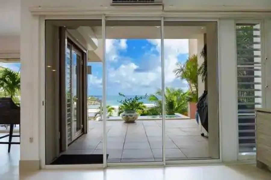 Ocean and plunge pool at Indigo Bay, framed by an open sliding door