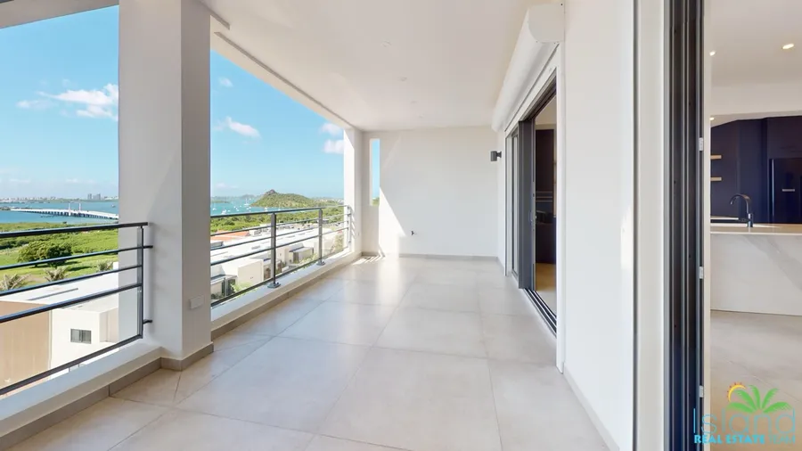 Open living level with floor-to-ceiling glass and terrace views at Plumbago Residences, Cole Bay