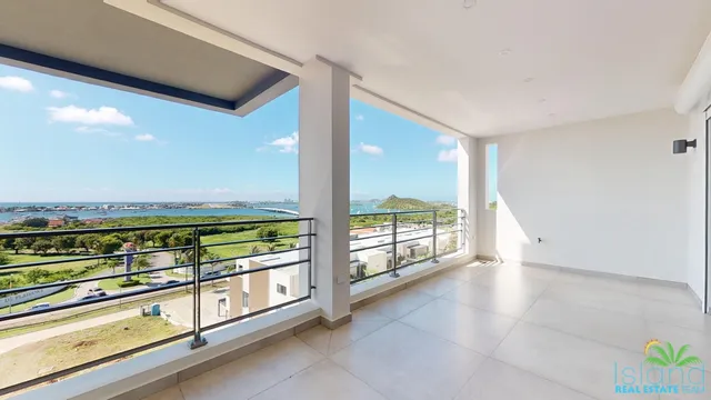 Open living space with corner glass and hillside views at Plumbago Residences
