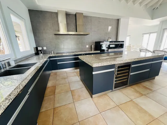 Kitchen with granite island, dark cabinetry and stainless appliances